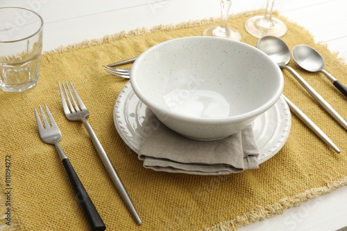 Stylish setting with cutlery  dishes and napkin on white wooden table