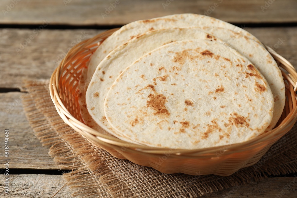 Tasty homemade tortillas in wicker basket on wooden table Tasty homemade tortillas in wicker basket on wooden table
