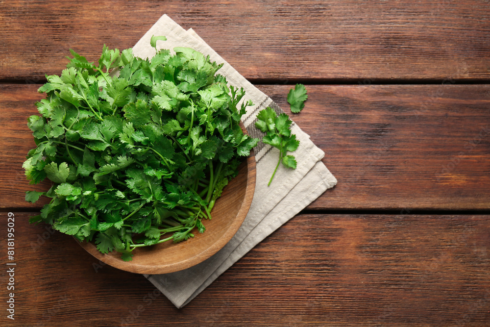 Fresh coriander in bowl on wooden table, top view. Space for text Fresh coriander in bowl on wooden table, top view. Space for text