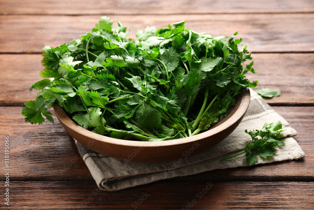 Fresh coriander in bowl on wooden table, closeup Fresh coriander in bowl on wooden table, closeup