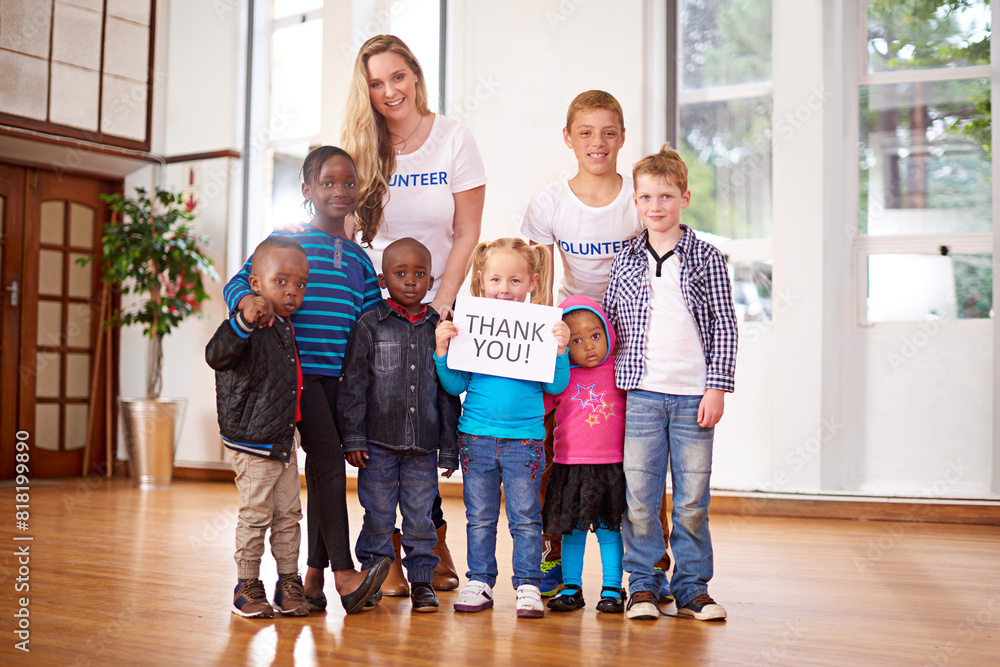 Children, volunteer and portrait at orphanage for donation, help and thank you sign for community service. Charity, kids and happy group with woman together at non profit ngo for support or gratitude Children, volunteer and portrait at orphanage for donation, help and thank you sign for community service. Charity, kids and happy group with woman together at non profit ngo for support or gratitude