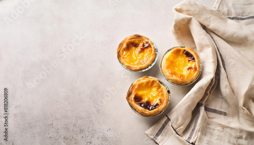 Three golden custard pies or "Pasteis de nata", typical pastry from Lisbon - Portugal. Egg tart on concrete table top, bathed in soft light. Generative Ai