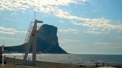 Slow motion, scene about a beach with a rock on an a lifeguard watchtower on background, in Calpe, Alicante (Spain) photo