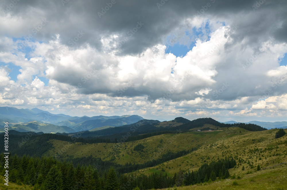Breathtaking view of rolling hills and green mountain ranges fading into the distance under a cloudy sky. Carpathian Mountains, Ukraine Breathtaking view of rolling hills and green mountain ranges fading into the distance under a cloudy sky. Carpathian Mountains, Ukraine