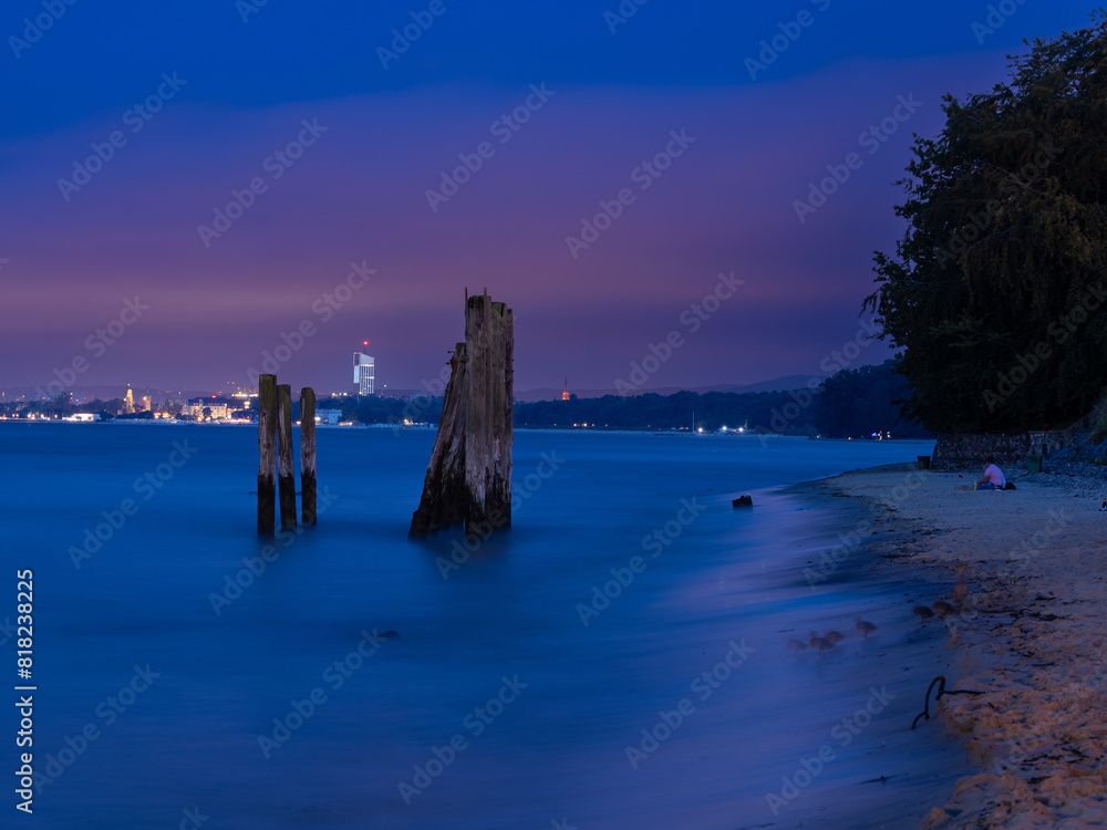 Remains of a pier sticking out of the sea at sunset on the Baltic Sea coast