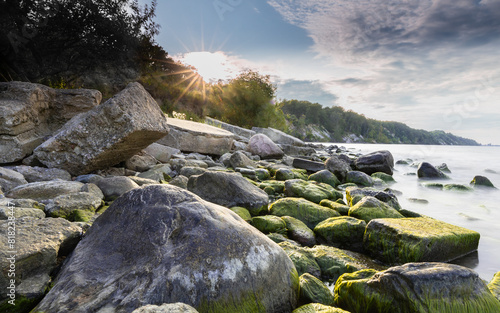 Obraz na płótnie Stones covered with moss on the background of the sunset on the Baltic coast w salonie