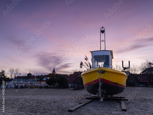 Obraz na płótnie Sunset against the background of an old fishing boat on the Baltic coast w salonie