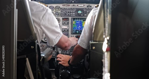Two pilots operate small aircraft cockpit photo