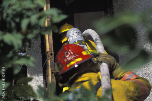 Fireman Pulling Hose To Building photo