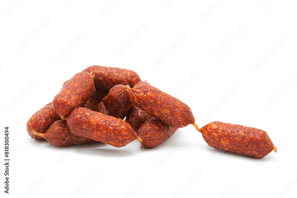 Pile of mini smoked dry-cured sausages isolated on a white background. Meat products and delicacies. Pile of mini smoked dry-cured sausages isolated on a white background. Meat products and delicacies.