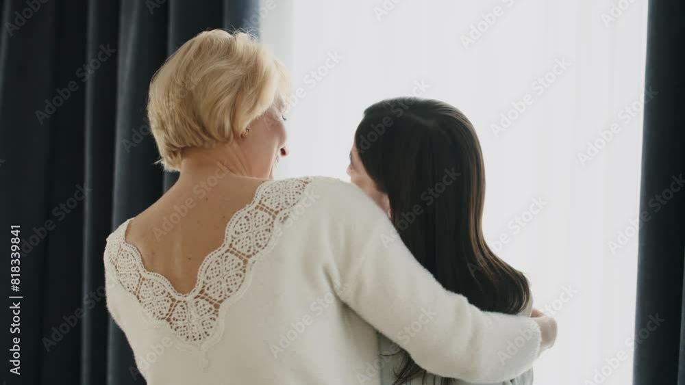 Concept family relationships. Pensioner mum comes to her adult daughter support in difficult days. Mature age mother embraces young daughter. Trust, support and help by mother Concept family relationships. Pensioner mum comes to her adult daughter support in difficult days. Mature age mother embraces young daughter. Trust, support and help by mother