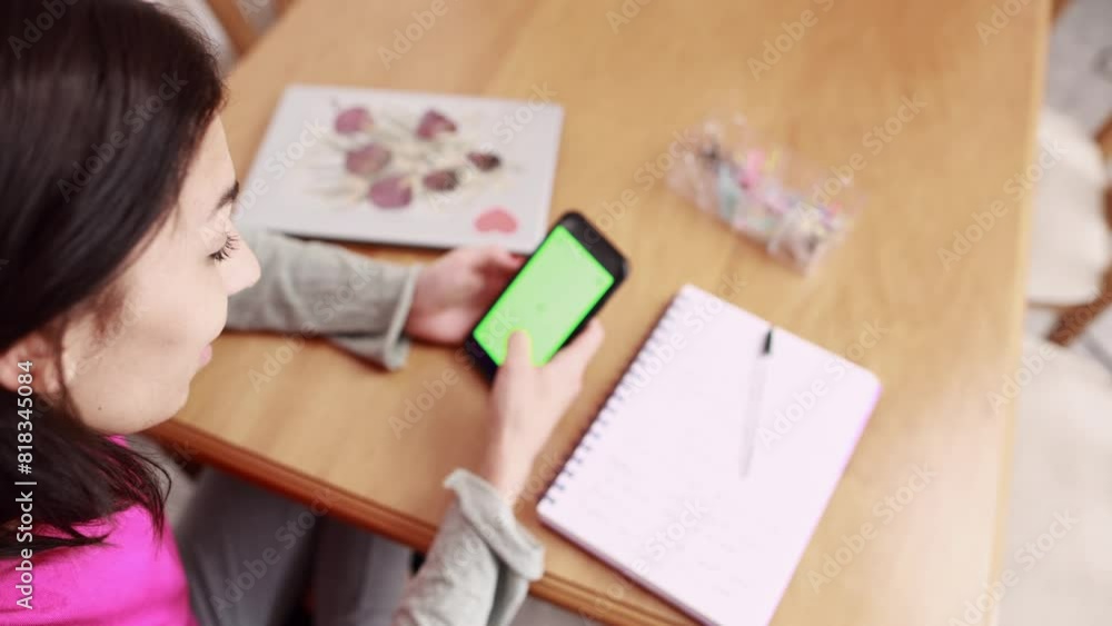 Chroma key green screen cellphone medium shot high angle social media browsing. Hispanic woman Chroma key green screen cellphone medium shot high angle social media browsing. Hispanic woman