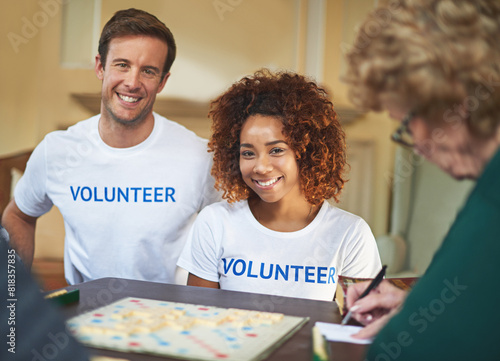 Volunteers, happy and portrait with senior people in retirement home, board game and social interaction for advocacy. Man, woman and elderly women with scrabble for volunteering and community service photo