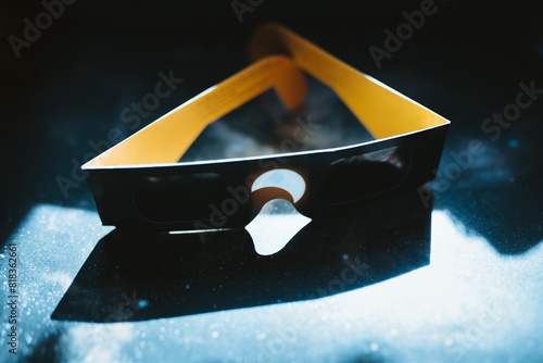 Solar eclipse glasses on a dark, dusty surface photo