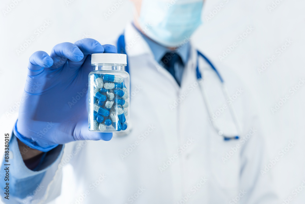 Doctor holding blue pills in bottle Doctor holding blue pills in bottle