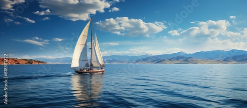 Sailboat Sailing in the middle of the sea isolated bluish clear sky photo