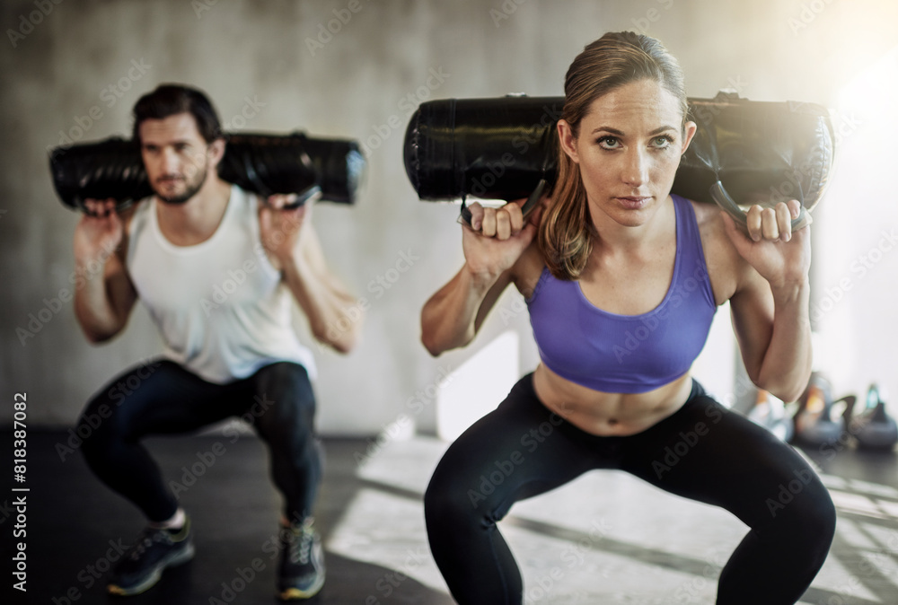 People, squat and sandbag workout or gym training with weightlifting for muscle growth, glutes or bodybuilding. Man, woman and personal trainer with equipment as athlete team, sports or discipline People, squat and sandbag workout or gym training with weightlifting for muscle growth, glutes or bodybuilding. Man, woman and personal trainer with equipment as athlete team, sports or discipline