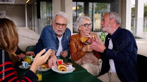Romance in the elderly. Group of happy residents friends of a geriatric. Mature gray hair at coffee bakery cafe terrace at nursing home having fun breakfast. Caucasian senior citizens people together