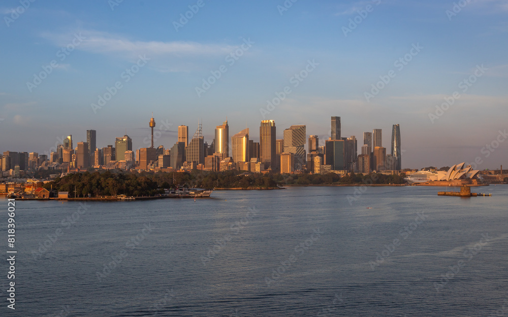 Obraz premium Extraordinary view of Sydney's Icons, namely the Sydney Opera House, Sydney Harbor Bridge and Sydney Downtown, while arriving by cruise ship in a beautiful sunrise.
