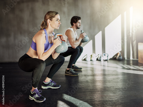 Muscle  squat and couple in gym with kettlebell  power training and workout challenge together at sports club. Man  woman or personal trainer with fitness development  healthy body and exercise.