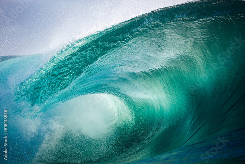 Beautiful jade colored ocean wave breaking over a shallow reef