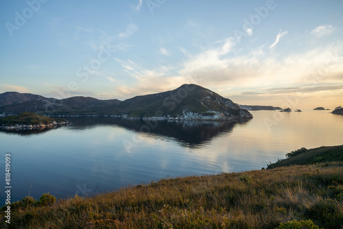 World heritage port davey national park in tasmania Australia, with mountains and river. boats in a bay in the evening photo