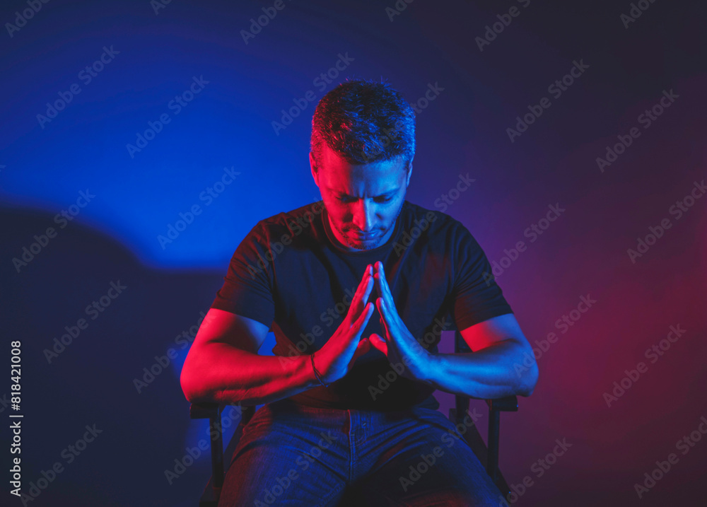 A man is sitting in a chair and praying A man is sitting in a chair and praying