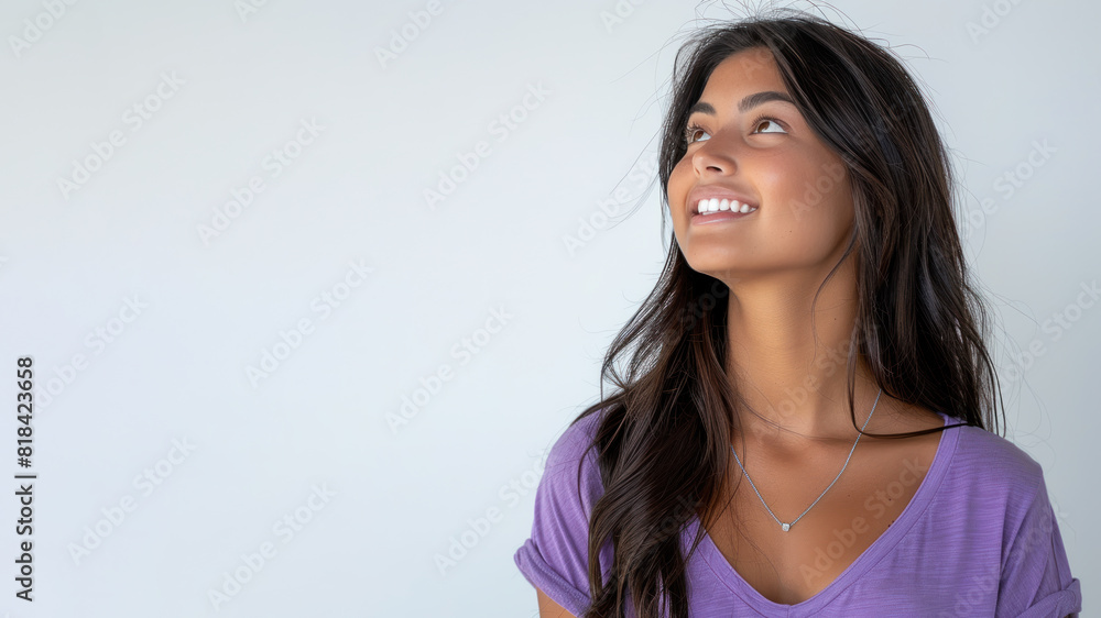 Indian woman wearing purple shirt smile looking up isolated on gray Indian woman wearing purple shirt smile looking up isolated on gray