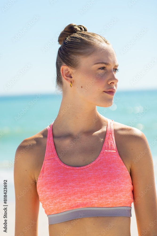 At beach, Caucasian young woman standing, looking away At beach, Caucasian young woman standing, looking away