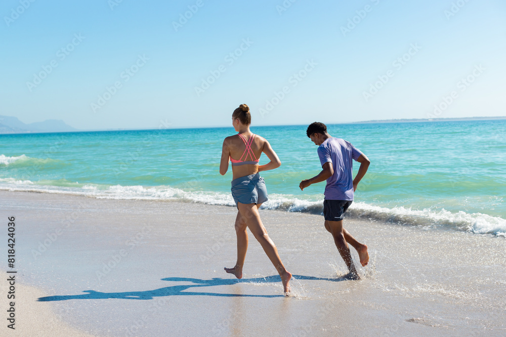 At beach, diverse couple running, holding hands At beach, diverse couple running, holding hands