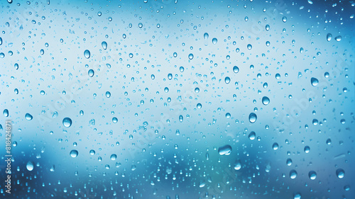 Raindrops on a glass window with a blue background.