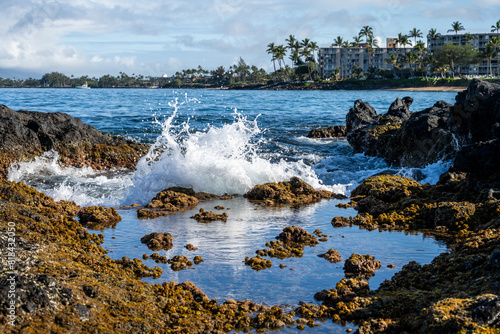Φωτογραφία Waves crashing on black lava rock at low tide, tide pool in foreground and resor