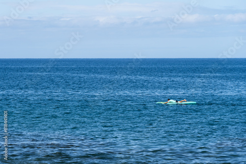Man in a turquoise rash guard shirt paddling on a turquoise paddleboard on a calm Pacific Ocean on a sunny day, Maui, Hawaii  © knelson20