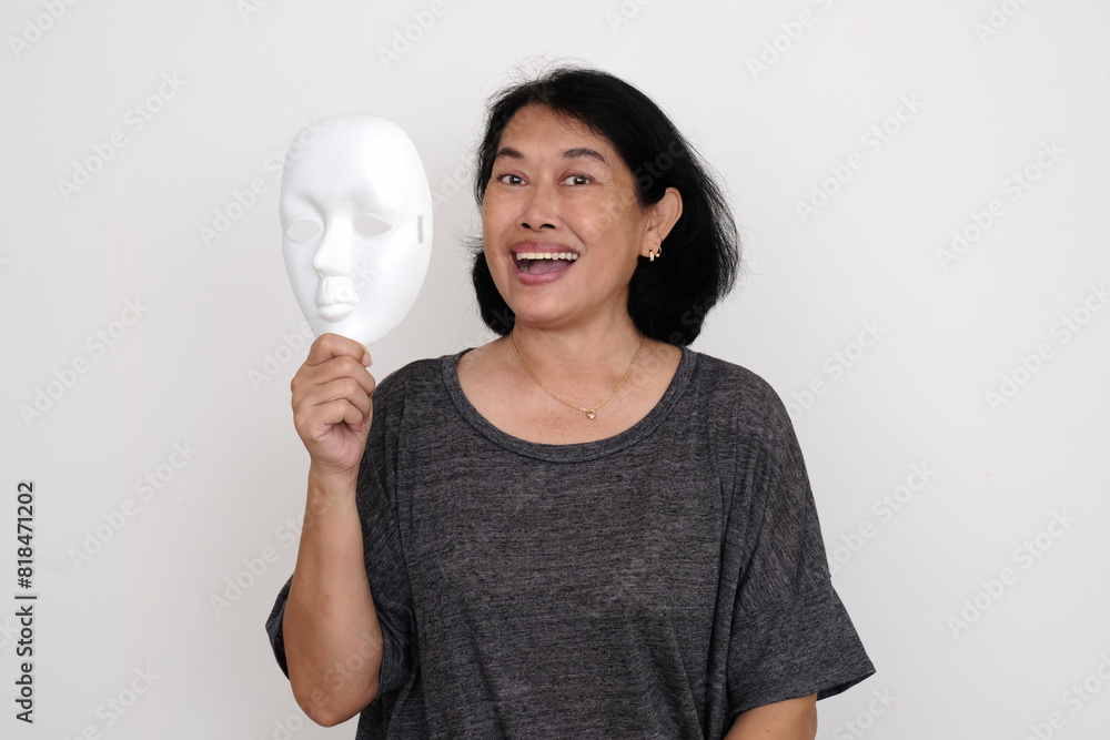 Woman in her casual clothes holding white mask beside her face Woman in her casual clothes holding white mask beside her face