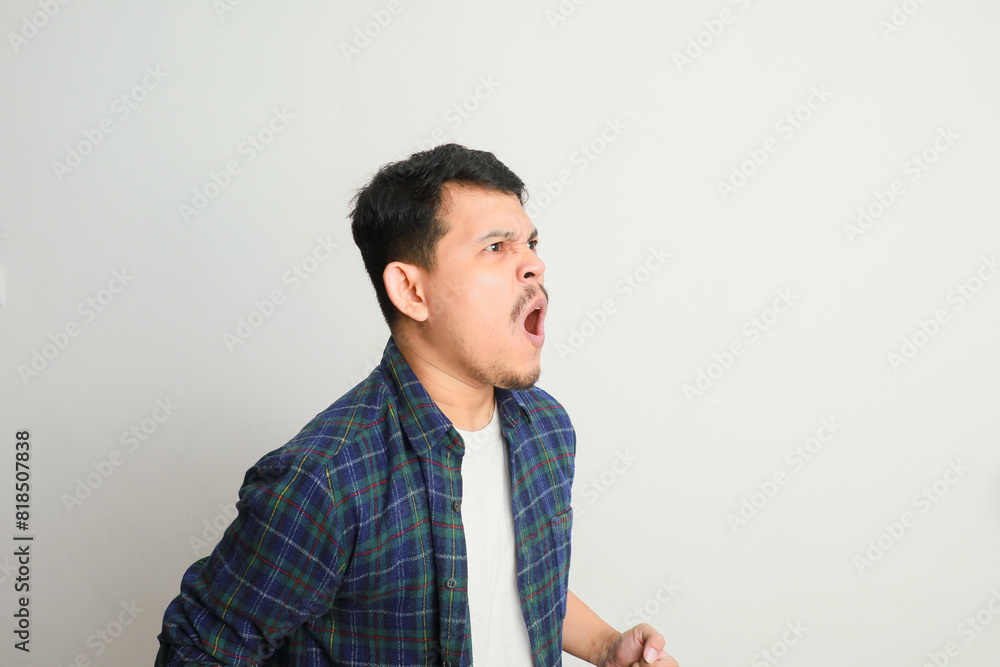 side view of young asian man with angry expression and shouting side view of young asian man with angry expression and shouting
