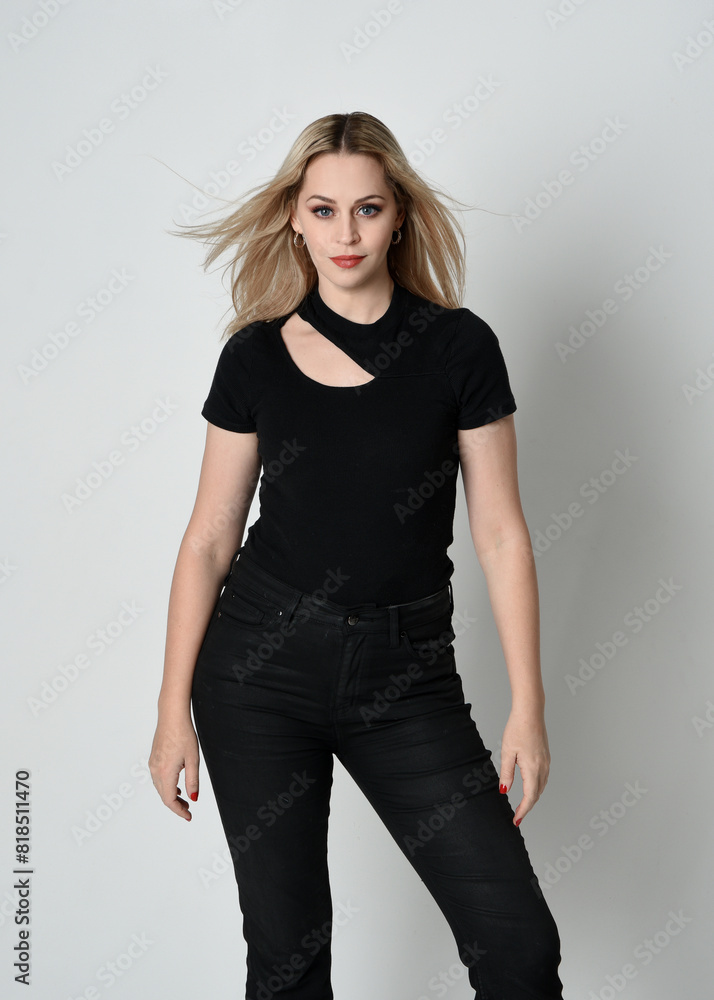 Close up portrait of beautiful blonde woman wearing modern black shirt and leather pants. Confident standing pose with hand gestures, isolated on white studio background. Close up portrait of beautiful blonde woman wearing modern black shirt and leather pants. Confident standing pose with hand gestures, isolated on white studio background.