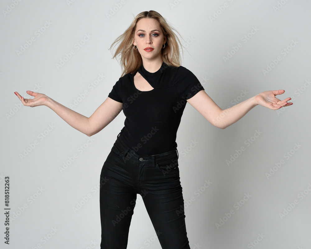 Close up portrait of beautiful blonde woman wearing modern black shirt and leather pants. Confident standing pose with hand gestures, isolated on white studio background. Close up portrait of beautiful blonde woman wearing modern black shirt and leather pants. Confident standing pose with hand gestures, isolated on white studio background.