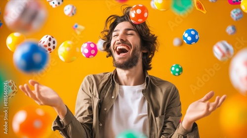 A man is laughing while throwing colorful balls. photo