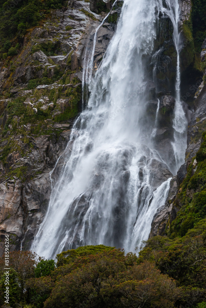 waterfall close up with water details dropping on rocks surrounded by green trees waterfall close up with water details dropping on rocks surrounded by green trees