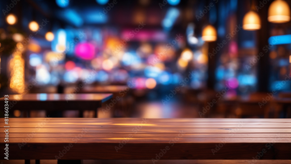 A wooden table in front of an out of focus bar with blue and purple lighting.


