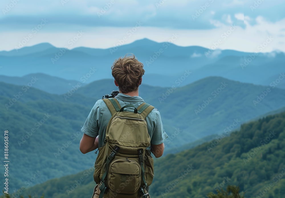 A handsome man carrying backpack and camera standing on the top of mountain with beautiful nature view background, back shot, copy space concept. A handsome man carrying backpack and camera standing on the top of mountain with beautiful nature view background, back shot, copy space concept.