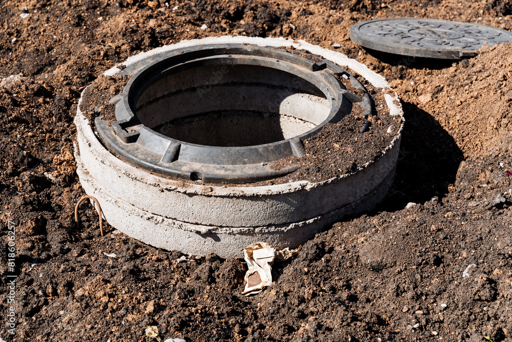 Dig Structure Construction site with exposed manhole, digging earth for concrete ...