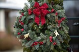 A wreath made of evergreen branches adorned with red berries and a festive bow,