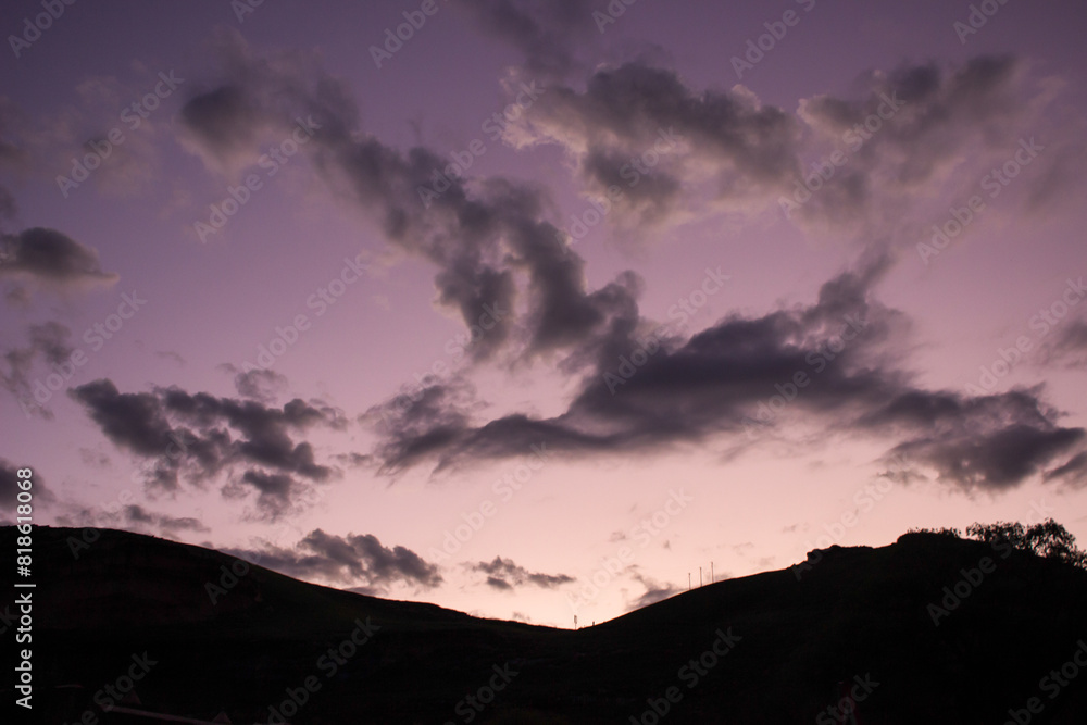 Slight winged shape of clouds in the purple sky of the early evening.