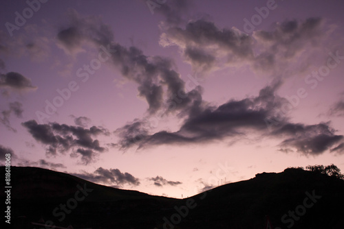 Slight winged shape of clouds in the purple sky of the early evening.