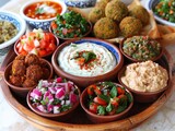 A variety of middle eastern food including hummus, falafel, and baba ghanoush.