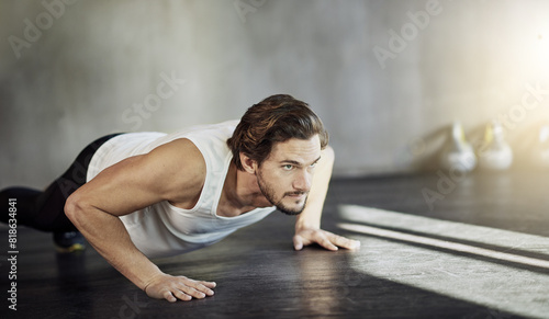 Man  push ups and strong exercise in gym  muscle gain and bodybuilder challenge or endurance. Male person  workout and bicep or core development  training routine and athlete for lifting body weight