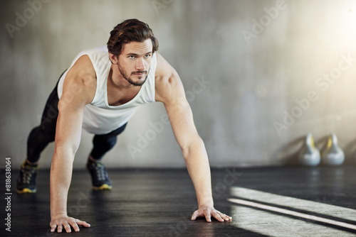 Health, exercise and man in gym with pushup for strong body, wellness and workout routine for arms. Sports club, plank action and male athlete with discipline for muscle growth and training goals