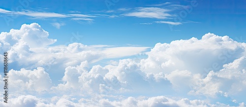 A vibrant blue sky filled with fluffy white clouds providing a perfect copy space image