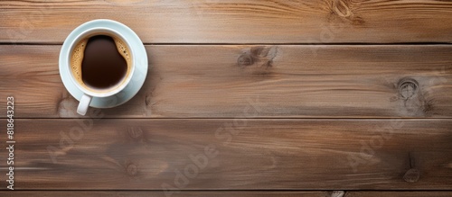 A top down view of an office desk displaying a cup of coffee with ample copy space for a flat lay image